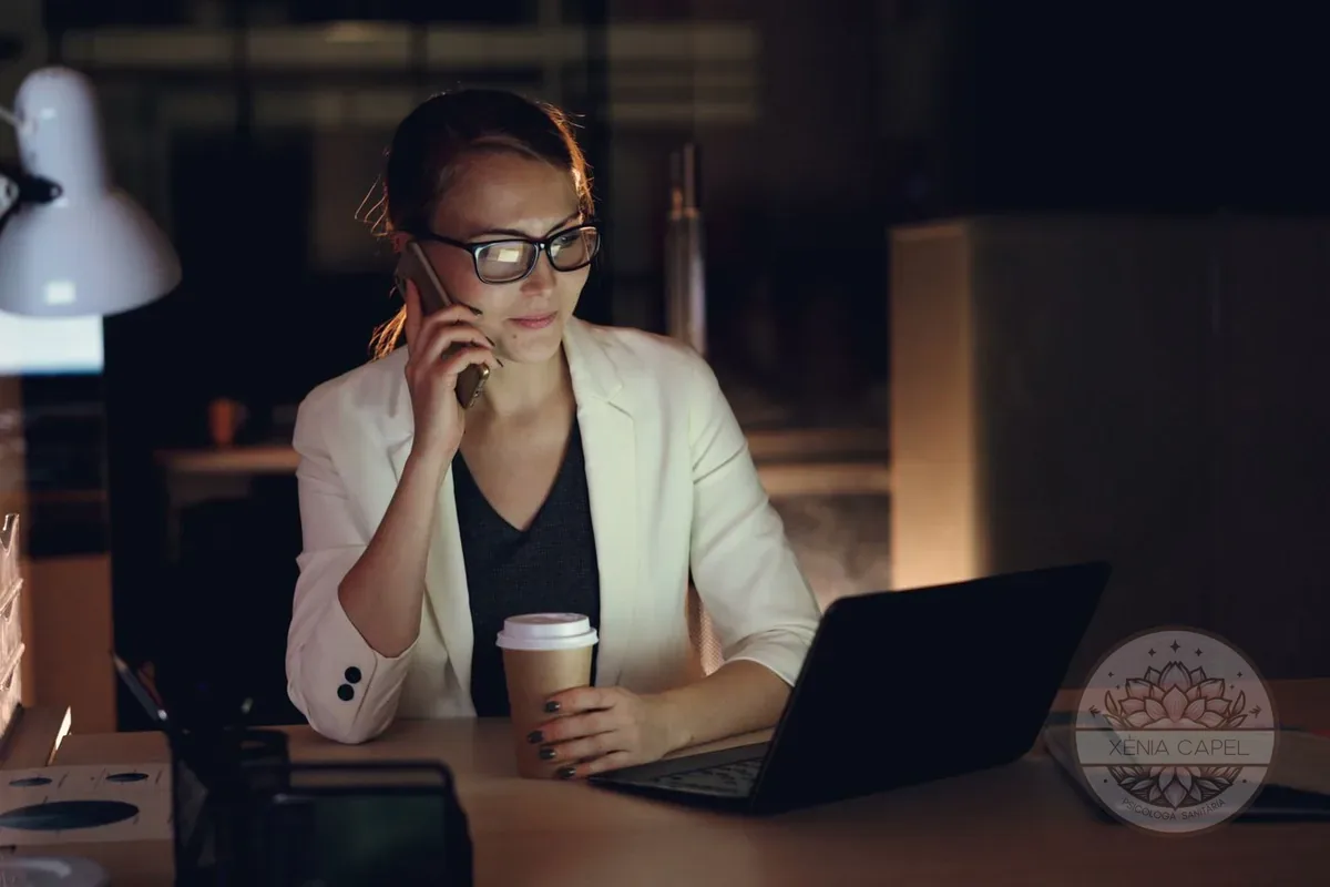 Work addiction: a woman working late at the office with a laptop, phone and coffee, unable to switch off