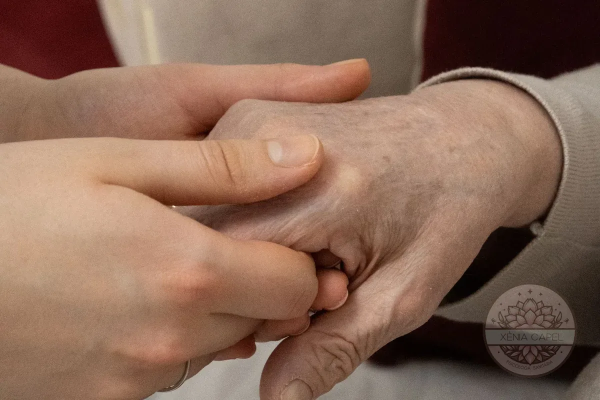 Anticipatory grief: a young hand tenderly holding an elderly person's hand, an example of accompanying and grieving a loss before it arrives