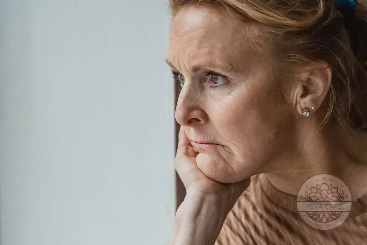 Menopausa i salut mental: una dona de mitjana edat pensativa vora la finestra