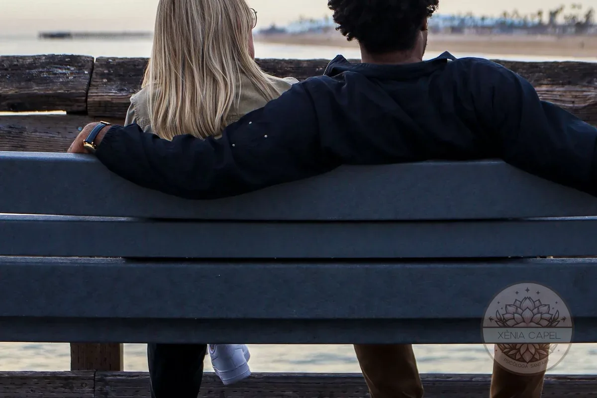 Miedo al compromiso: pareja de espaldas en un banco mirando el horizonte, con una distancia sutil entre ambos