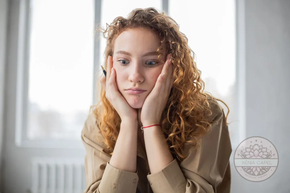 Pensamiento catastrófico: mujer joven con gesto de preocupación imaginando lo peor, con las manos en la cara