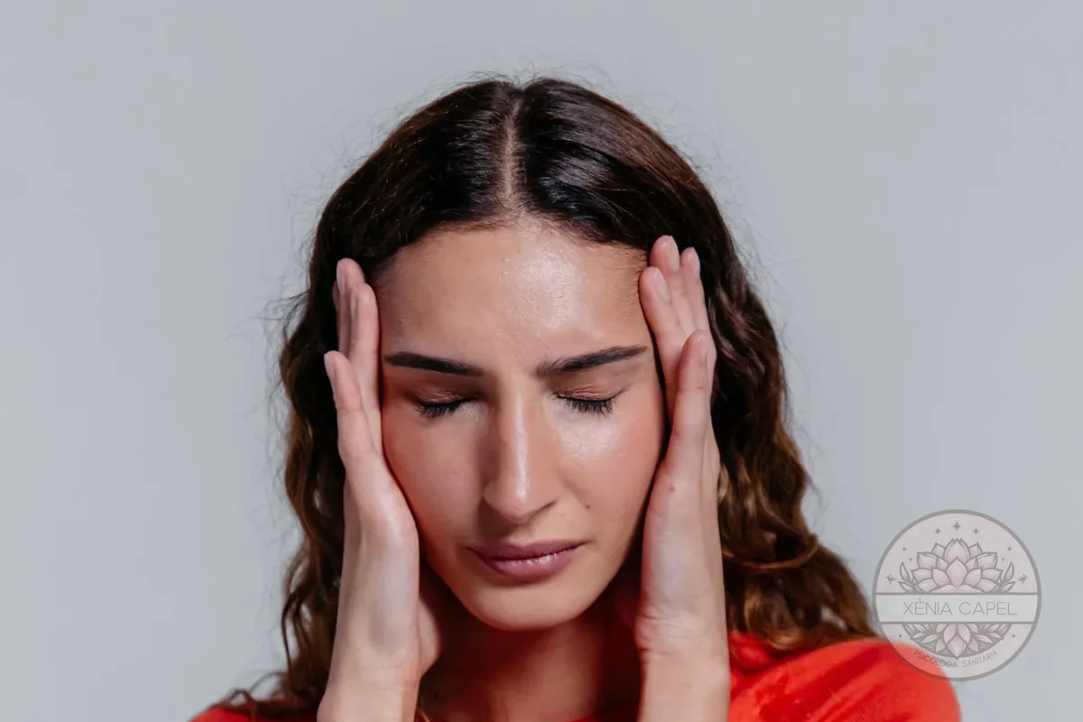 Intrusive thoughts: a young woman with her hands on her temples, overwhelmed by her thoughts