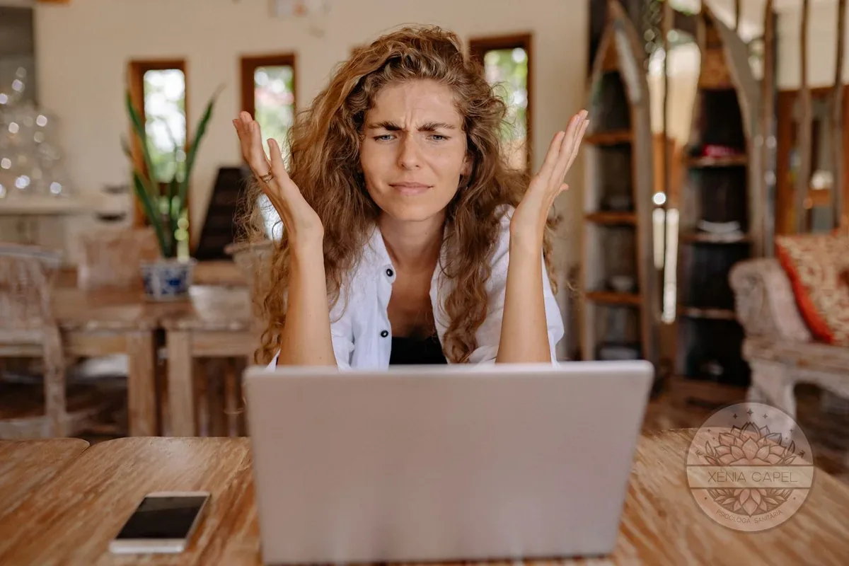 Tolerancia a la frustración: mujer joven con gesto de exasperación ante el portátil, frustrada porque las cosas no salen